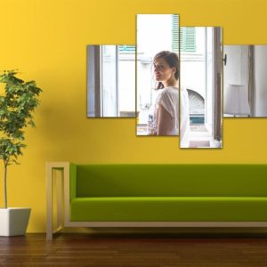 Bright yellow wall with modern green sofa and multi-panel mirror art, stylish home decor, interior design inspiration.
