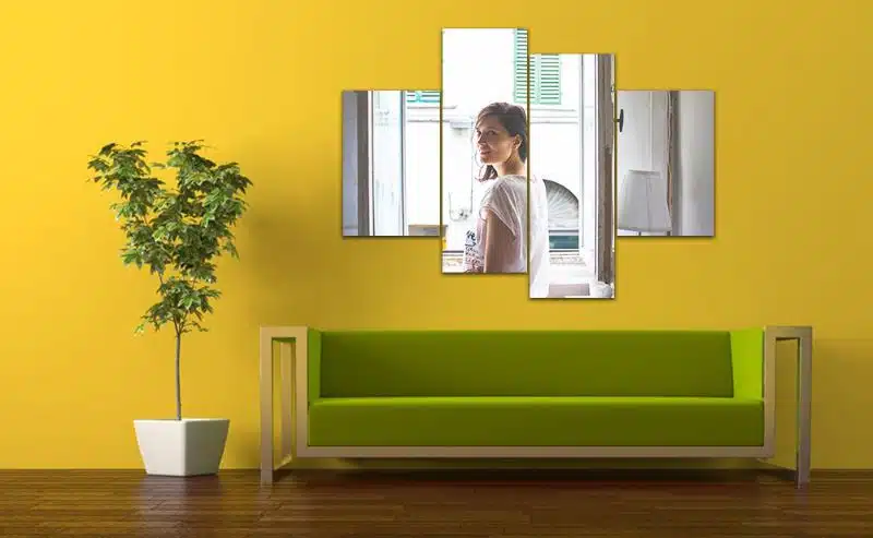 Bright yellow wall with modern green sofa and multi-panel mirror art, stylish home decor, interior design inspiration.