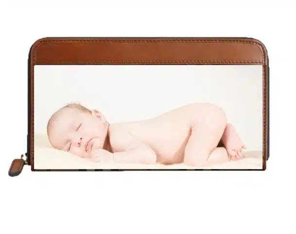 Baby sleeping photo on a white background in a brown leather wallet case, ideal for newborn photography props. The wallet features a transparent pocket.
